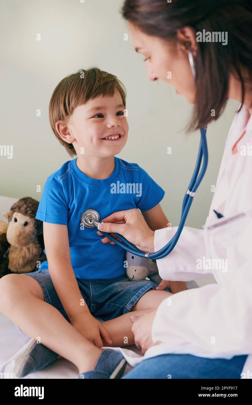 Ist mein Herz gesund, Doktor? Eine Ärztin, die die Herzfrequenz ihrer jungen Patienten überprüft. Stockfoto