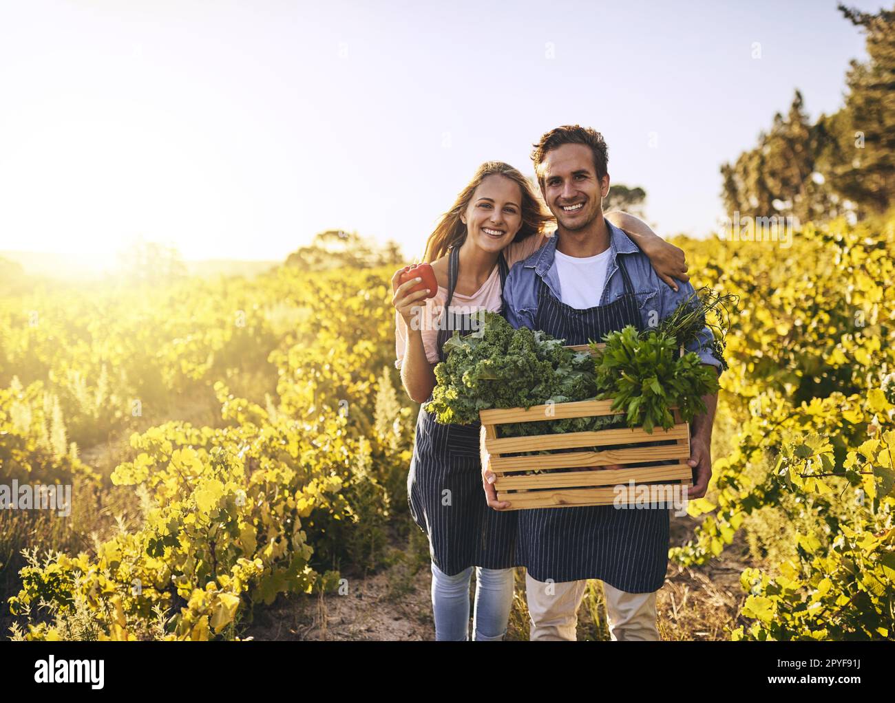 Reif und bereit zum Fressen. Ein junger Mann und eine junge Frau arbeiten zusammen auf einem Bauernhof. Stockfoto