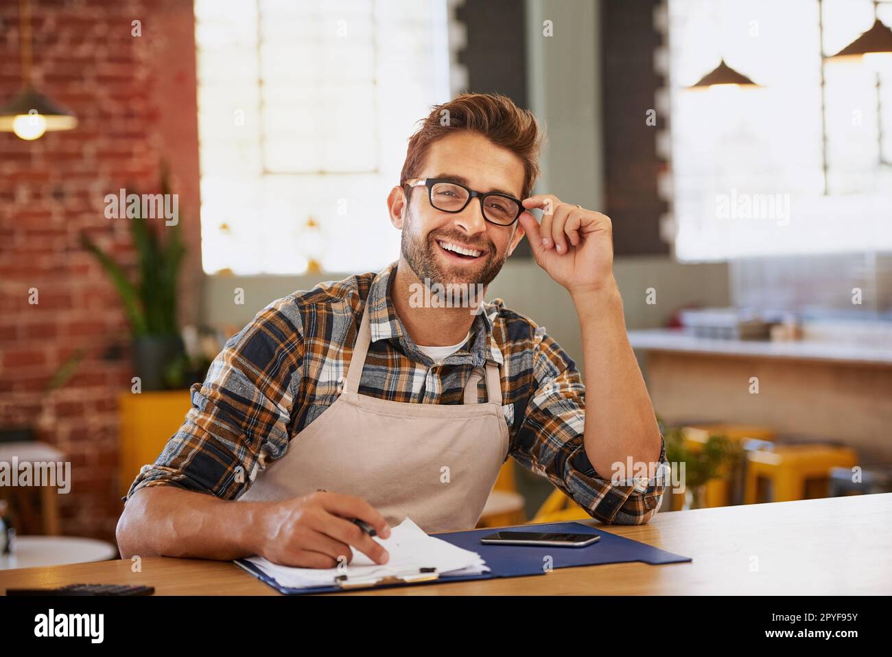 Ich bin ein Champion bei der Verwaltung. Porträt eines glücklichen jungen Geschäftsbesitzers, der an einem Tisch in seinem Café als Verwalter tätig ist. Stockfoto
