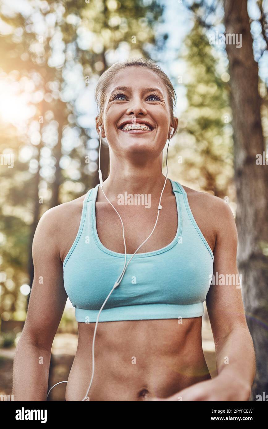 Bauchmuskeln bilden sich mit einem guten Lachen. Porträtaufnahme einer jungen Frau, die draußen lächelt. Stockfoto