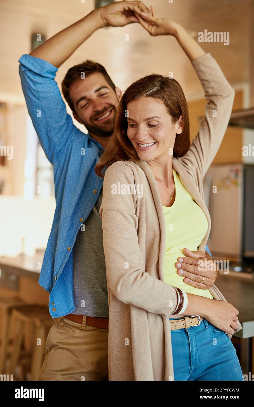 Jeder Tanz gehört ihm. Ein liebevolles junges Paar, das in der Küche tanzt. Stockfoto