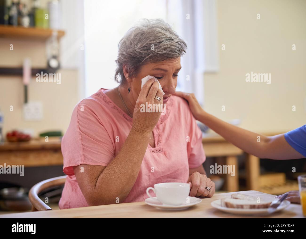 Ich fühle mich von Trauer und Trauer überwältigt. Eine Pflegekraft tröstet einen Seniorenpatienten in einem Pflegeheim. Stockfoto