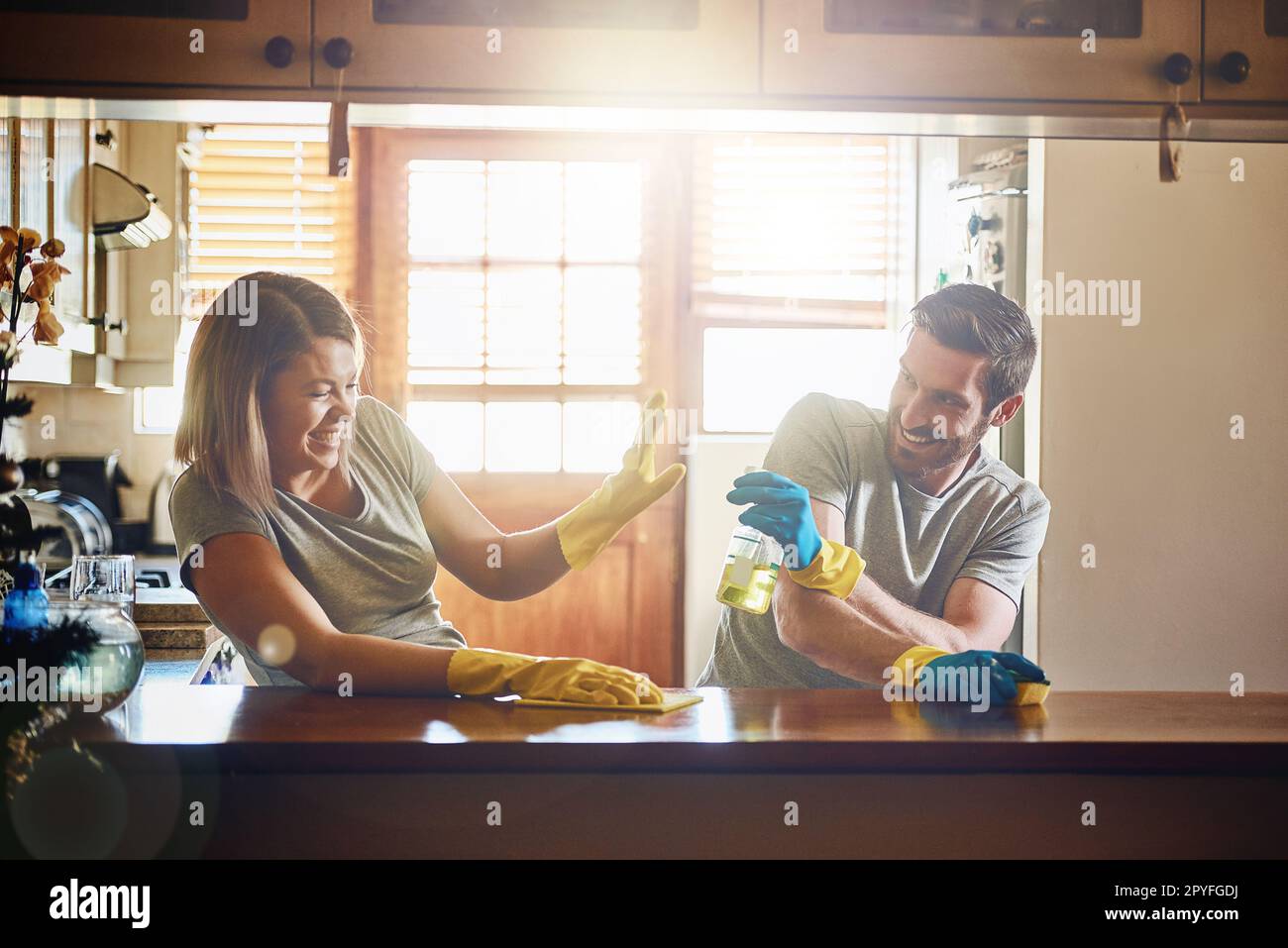 Herummachen ist Teil des Spaßes. Ein junges Paar, das sich amüsiert, während es zu Hause Hausarbeiten macht. Stockfoto