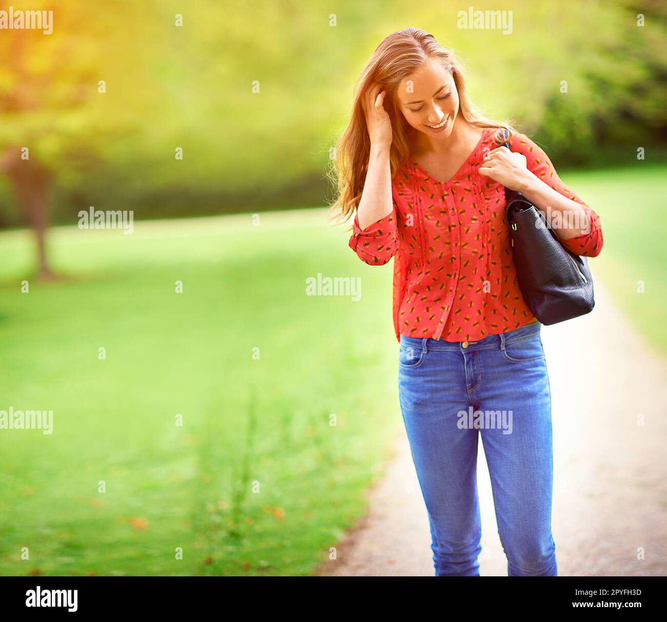 Momente der Glückseligkeit im Freien. Eine junge Frau auf einem Spaziergang durch den Park. Stockfoto
