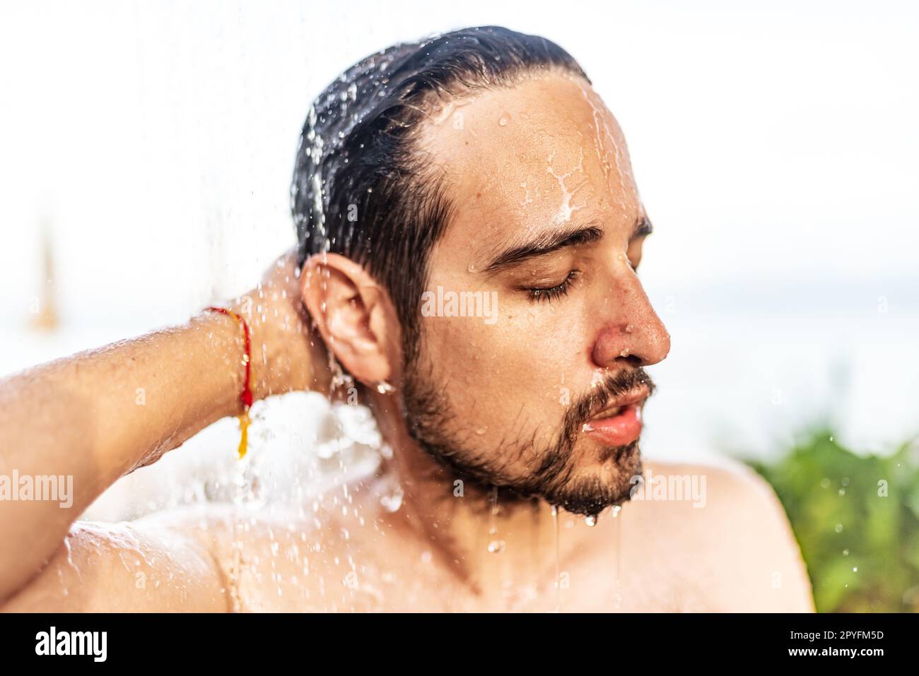 Ein Mann, der unter der Dusche steht. Stockfoto