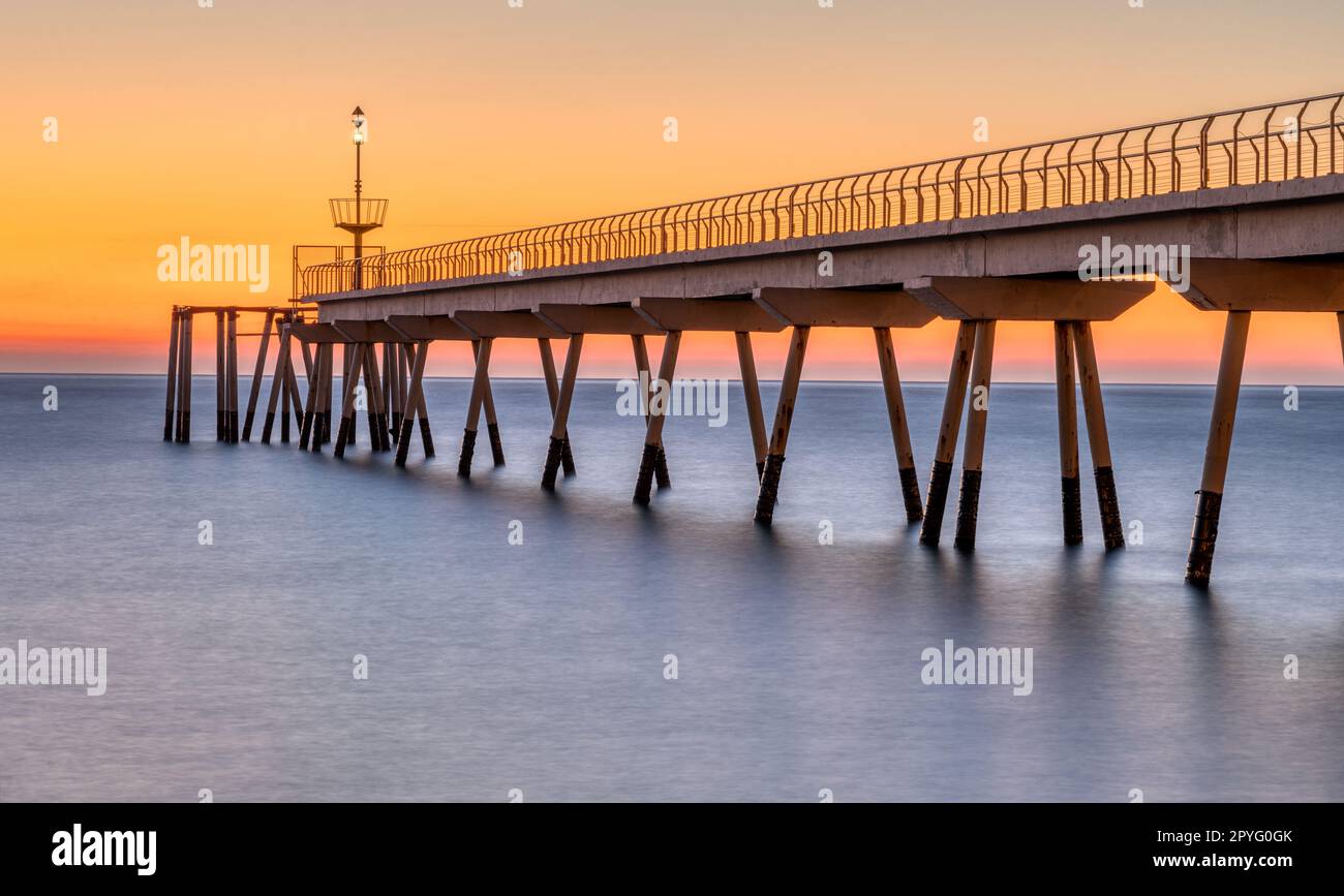 Die Pont del Petroli, der Seepier von Badalona in Spanien, vor Sonnenaufgang Stockfoto