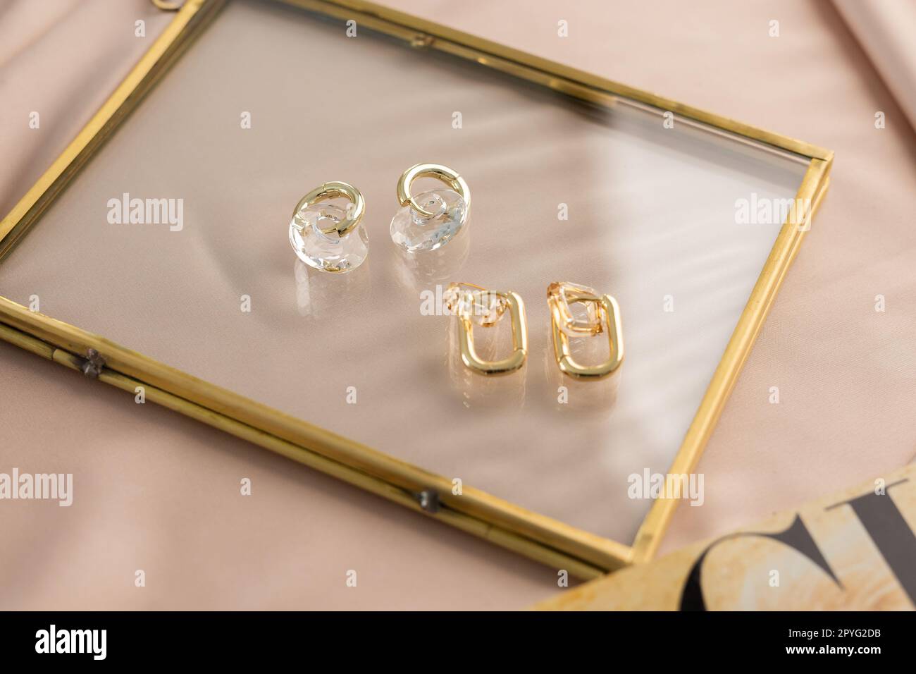Elegantes Schmuckset mit goldenen Ohrringen. Schmuckset im minimalistischen Stil. Handgefertigtes Bijouterie-Konzept. Stockfoto
