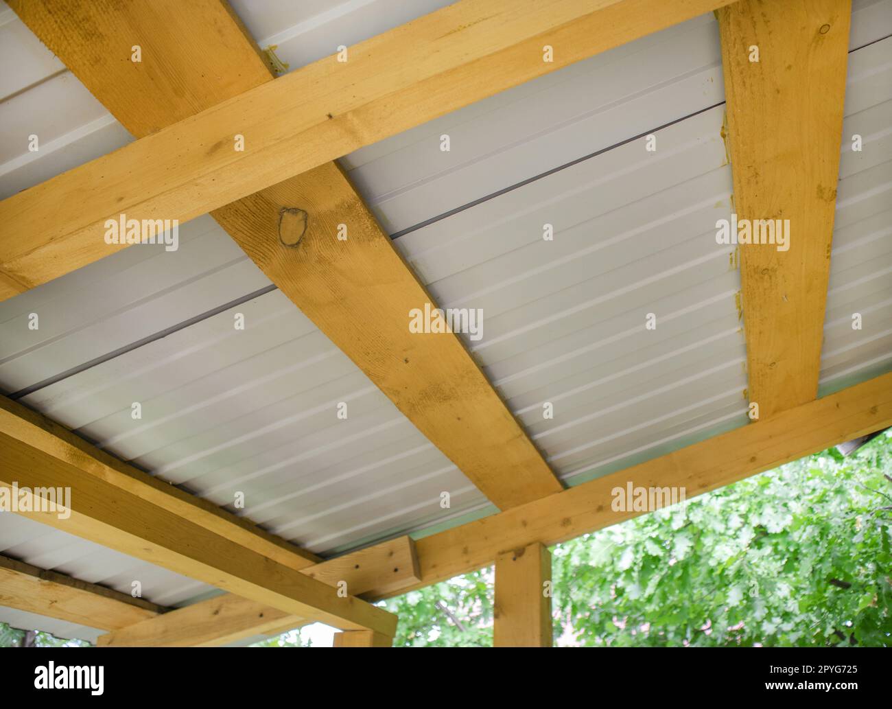 Nahaufnahme von Dachsparren aus Holz mit Wellpappe aus Metall, Ansicht von unten Stockfoto