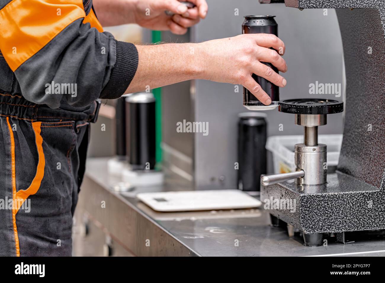 Verschlossen mit dem Deckel von Getränkedosen in einer automatischen Verschlussmaschine in einer Brauerei Stockfoto