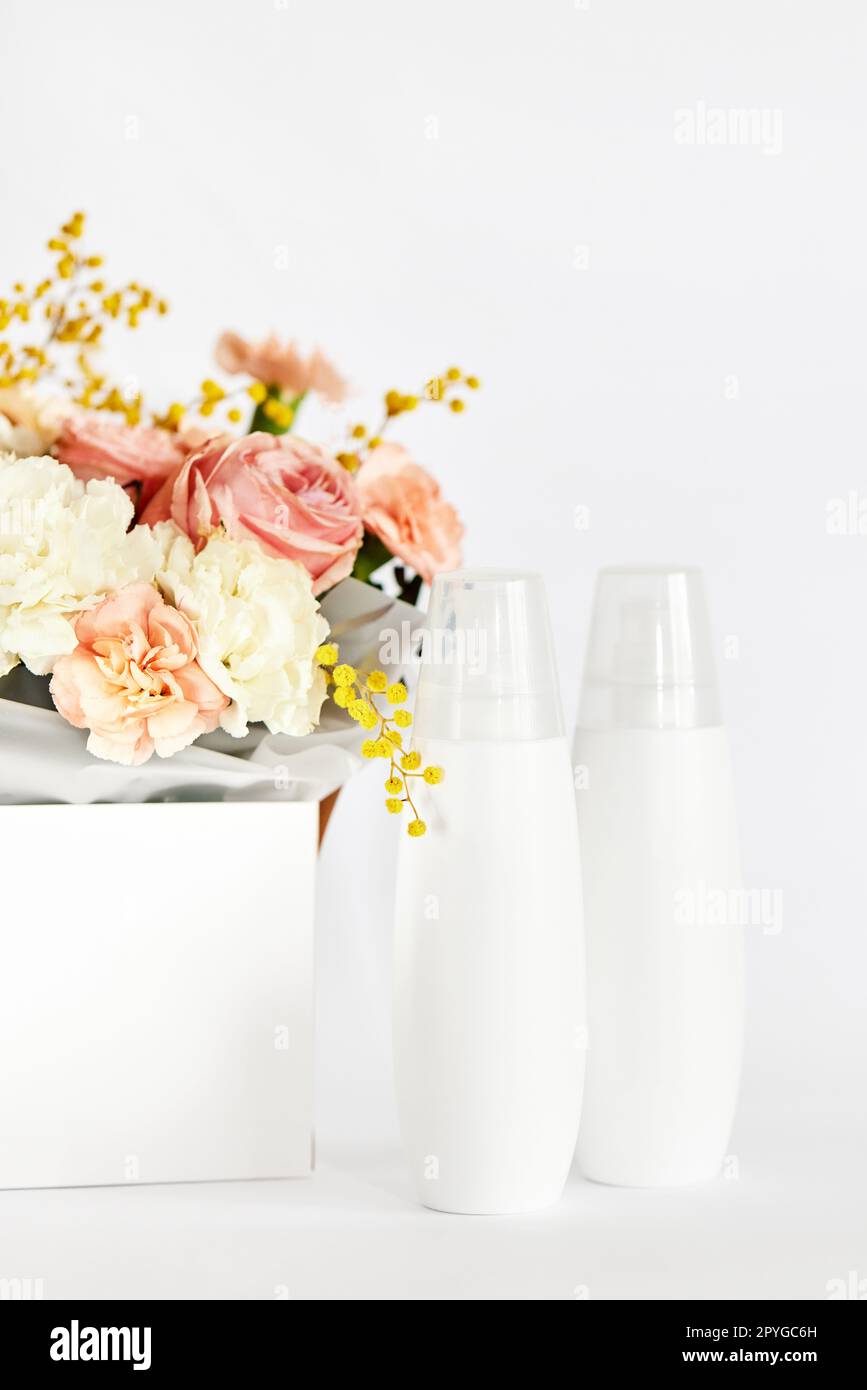 Kosmetik-Schönheitsprodukt-Flaschenmodell und Blume Stockfoto