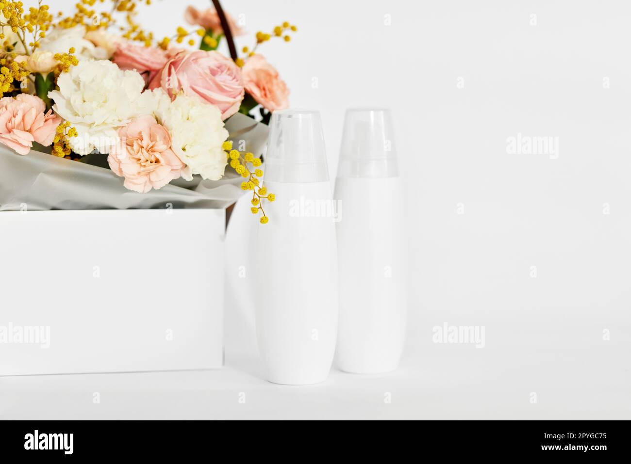 Kosmetik-Schönheitsprodukt-Flaschenmodell und Blume Stockfoto