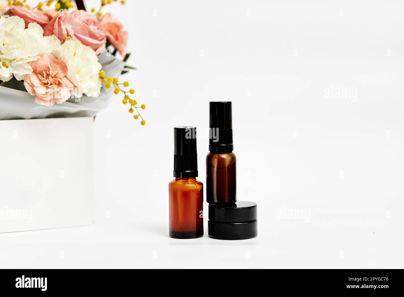 Kosmetik-Schönheitsprodukt-Flaschenmodell und Blume Stockfoto