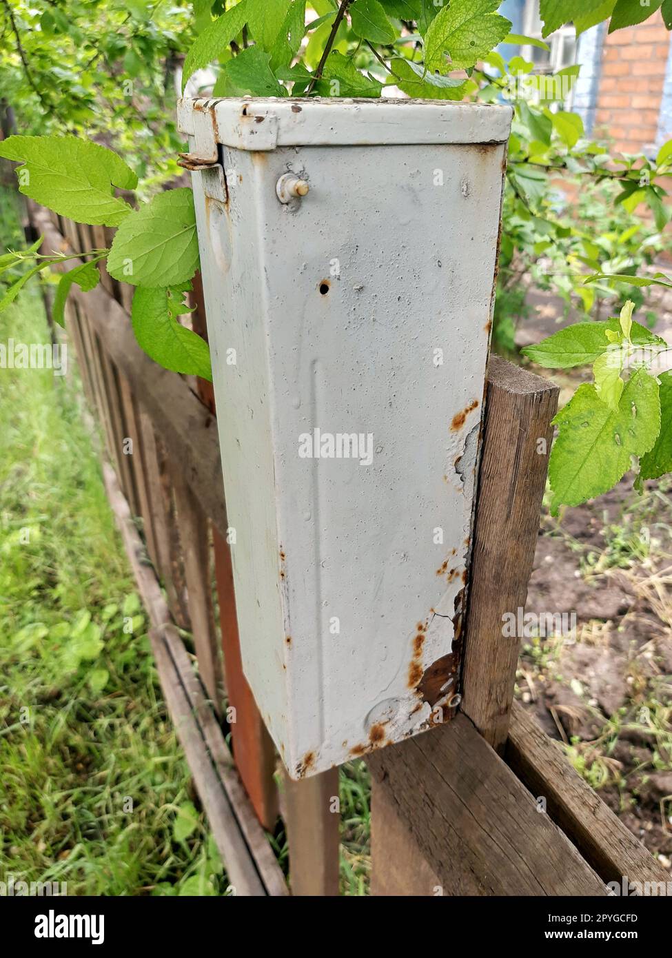 Ein alter Briefkasten auf einem Holzzaun Stockfoto
