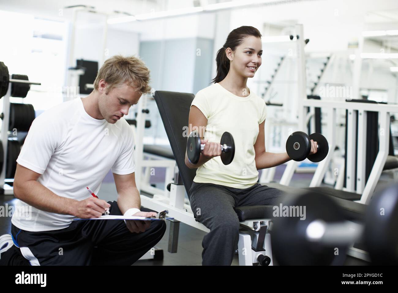 Sie will fit werden. Eine attraktive junge Frau mit ihrem persönlichen Trainer. Stockfoto