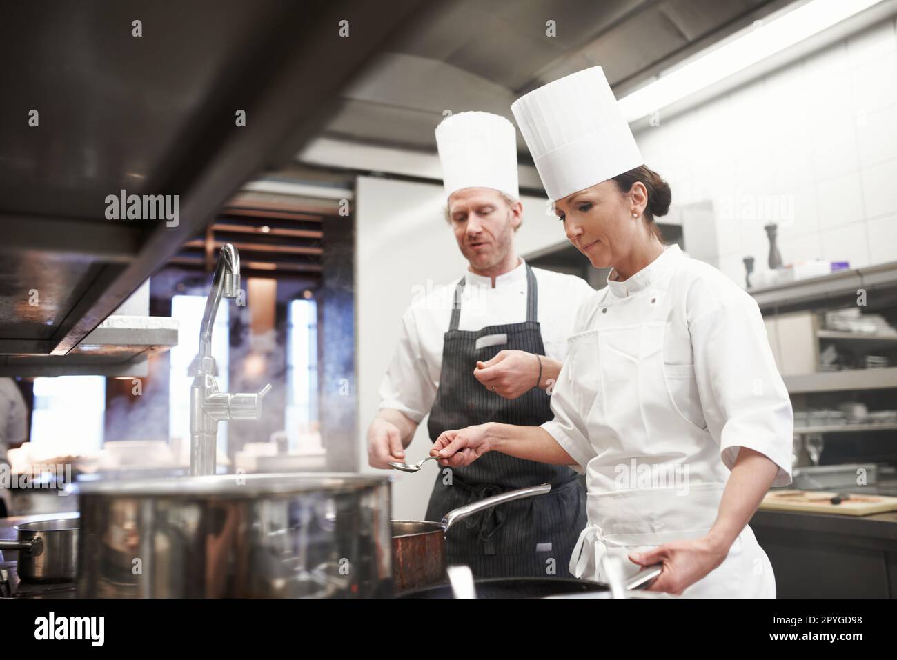 Gastronomiekünstler bei der Arbeit. Das Innenleben einer professionellen Küche. Stockfoto