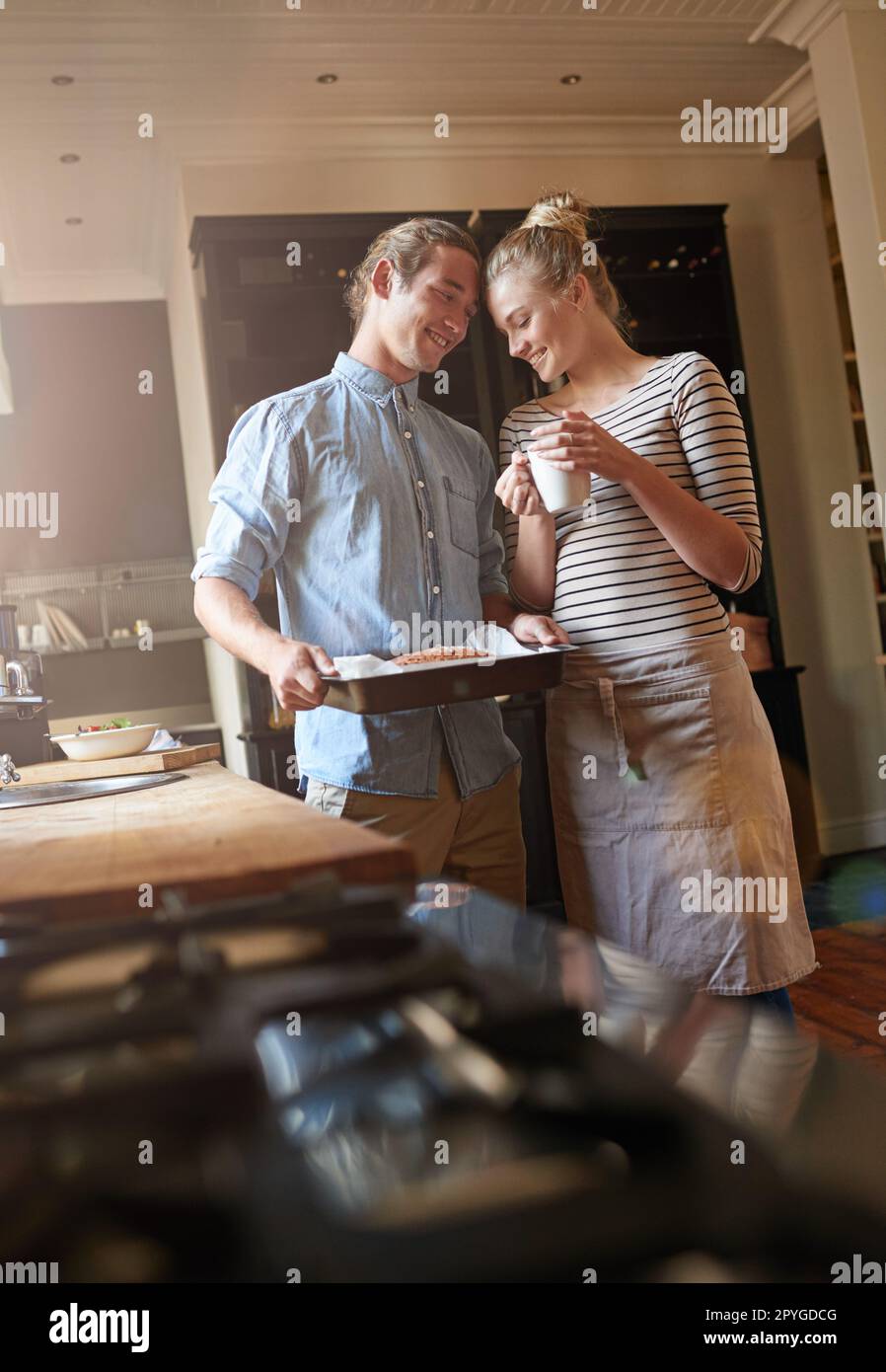 Backen ist Liebe, die sichtbar gemacht wird. Ein junges Paar, das sich in der Küche anfreundet. Stockfoto