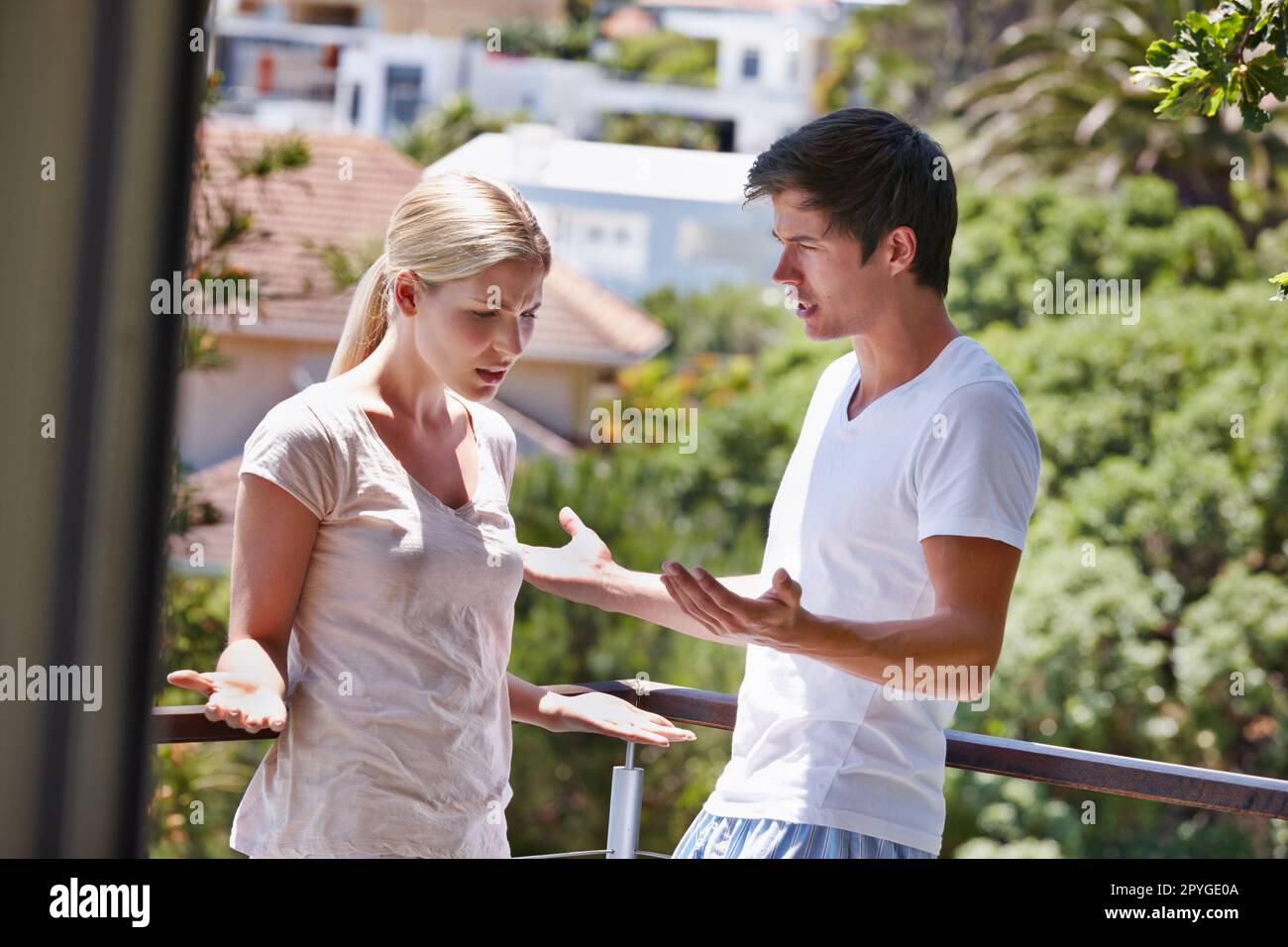 Willst du wirklich so den Tag beginnen? Ein junges Paar, das sich auf dem Balkon ihres Hauses gestritten hat. Stockfoto