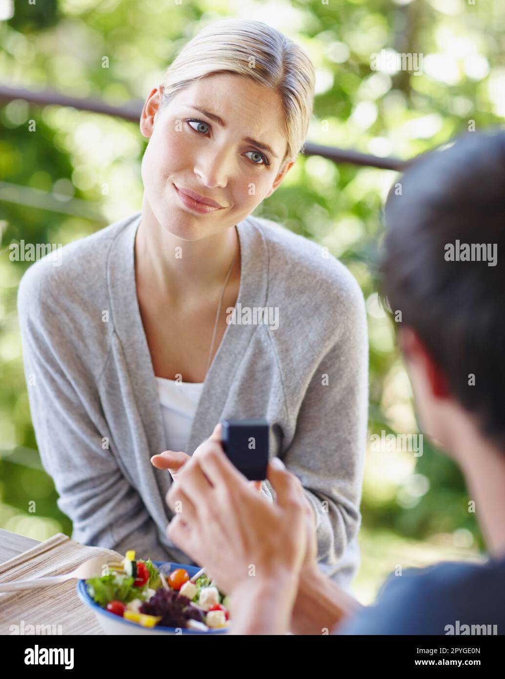 Das ist so süß, Babe. Eine schöne junge Frau, die unsicher aussieht, als ihr Freund einen Antrag macht. Stockfoto