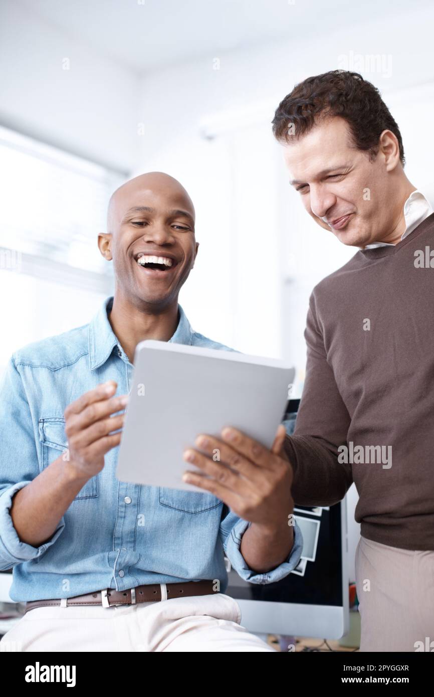 Markttrends recherchieren. Zwei Geschäftsleute teilen sich am Arbeitsplatz ein digitales Tablet. Stockfoto