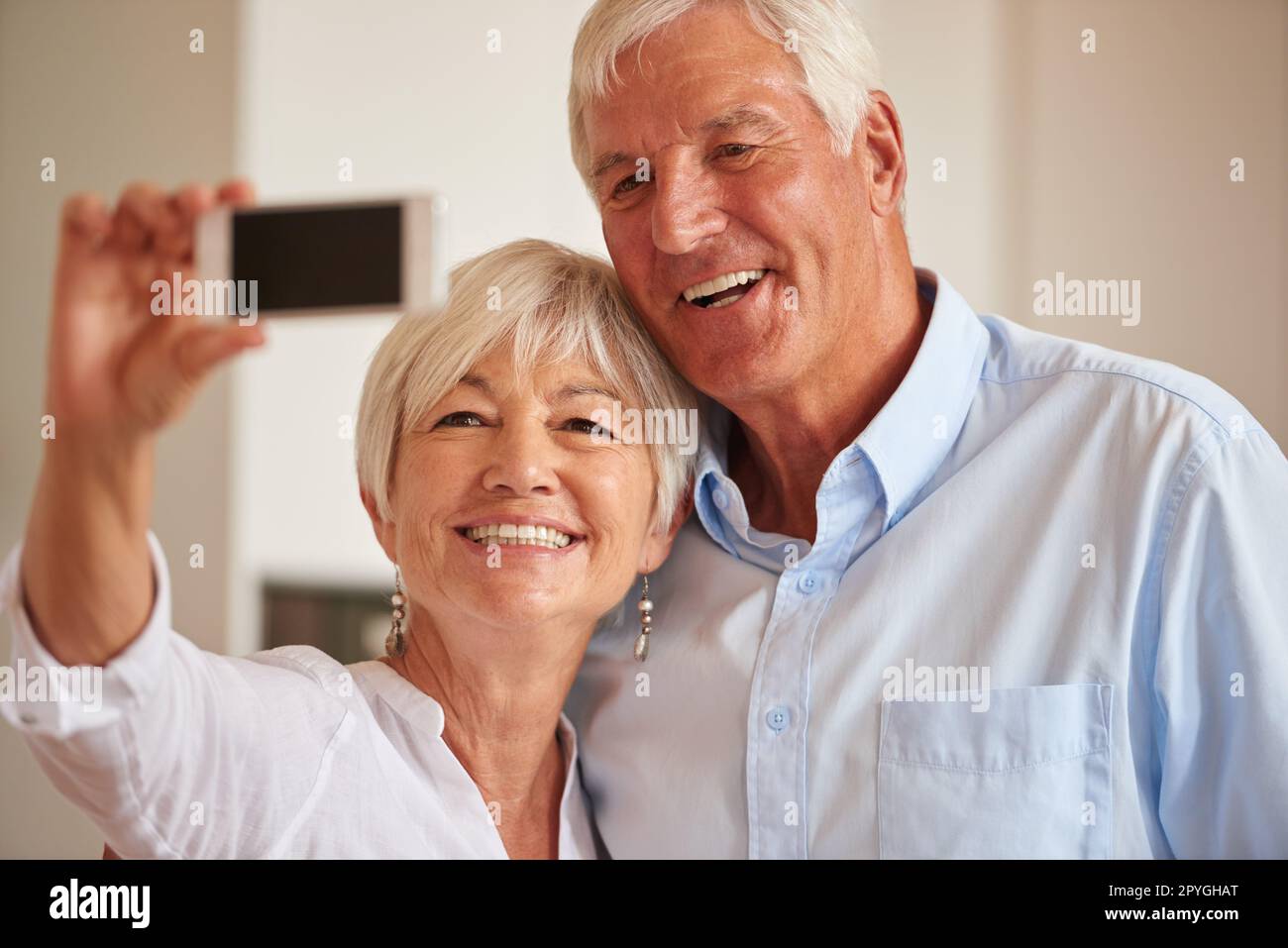 Sie fangen ihre goldenen Jahre ein. Ein Seniorenpaar, das ein Selfie mit seinem Handy macht. Stockfoto