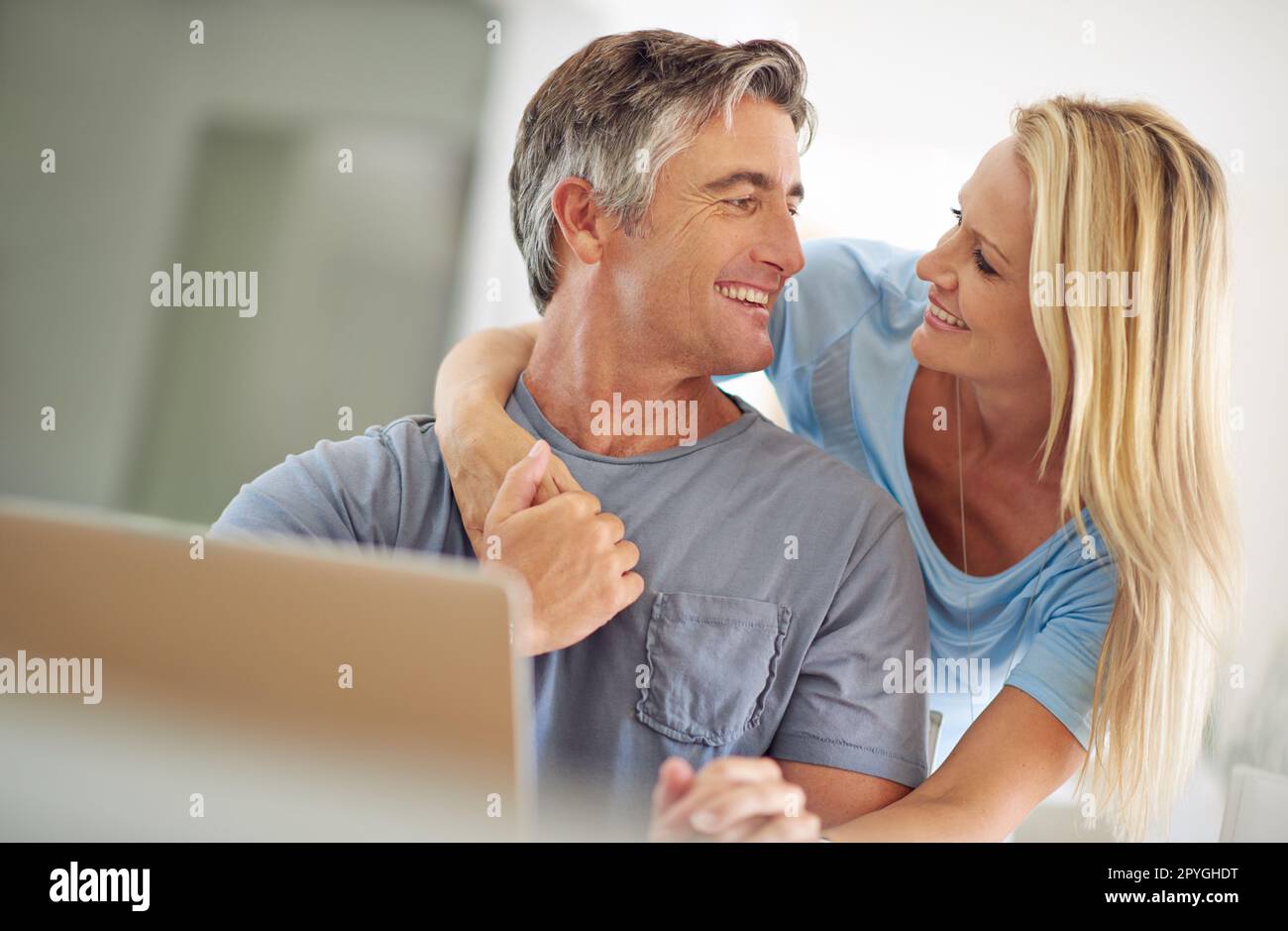 Unser Urlaub ist ausgebucht. Ein glückliches, reifes Paar, das zu Hause ein Notebook benutzt. Stockfoto