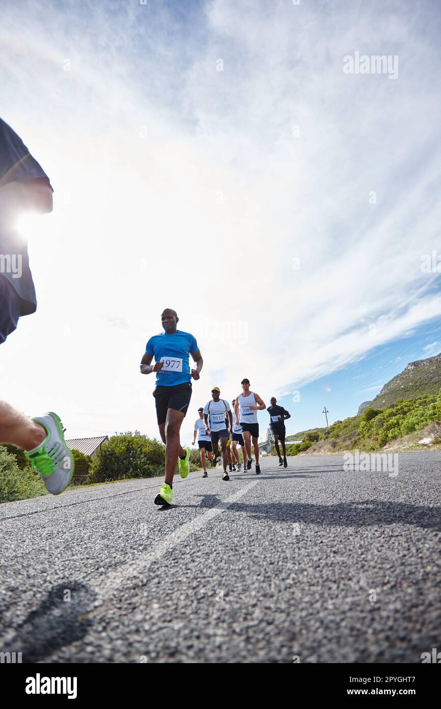 Lassen Sie uns beharrlich vorgehen. Eine Gruppe junger Männer, die einen Marathon laufen. Stockfoto