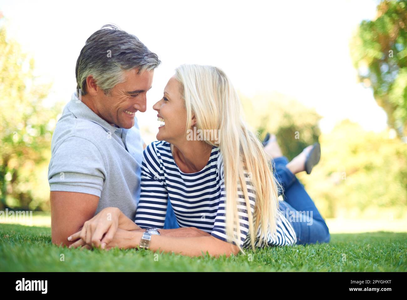 Konversation und Gesellschaft. Die volle Länge eines liebevollen, reifen Ehepaars, das im Park von Angesicht zu Angesicht liegt. Stockfoto