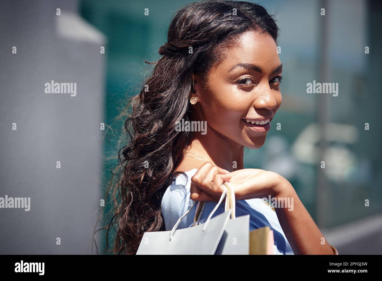 Tun Sie mehr von dem, was Sie glücklich macht. Porträt einer schönen Frau, die ihre Einkaufstüten in der Hand hält. Stockfoto