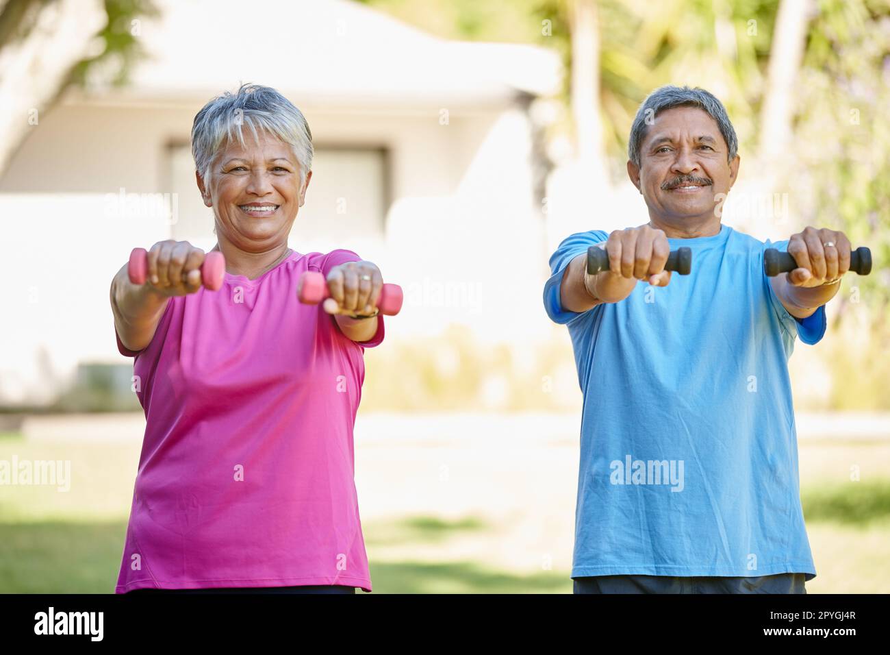 Zusammen fit und gesund bleiben. Porträt eines erwachsenen Ehepaars, das zusammen im Garten trainiert. Stockfoto