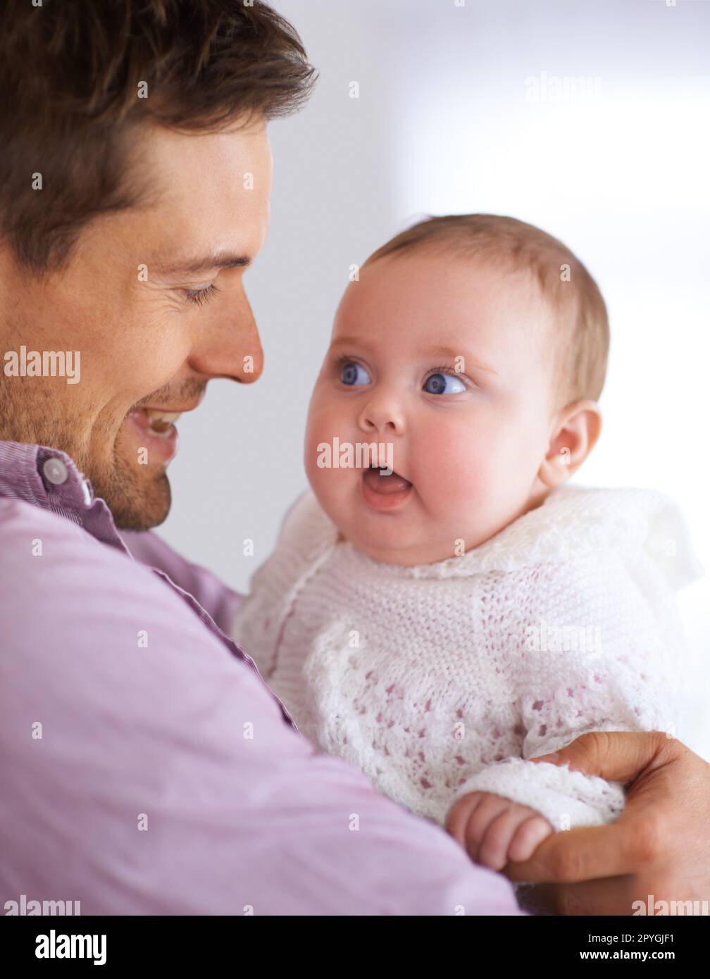 Eine Beziehung zum Baby aufbauen. Ein junger Vater, der sein süßes Mädchen hält. Stockfoto
