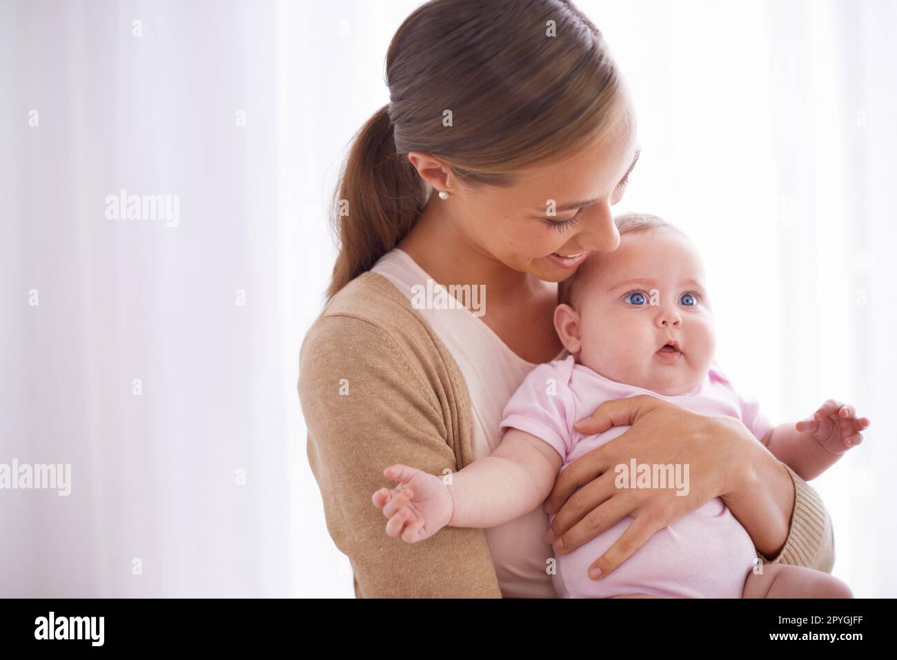 Sie ist so ein Freudenbündel. Eine junge Mutter, die sich mit ihrem kleinen Mädchen anfreundet. Stockfoto