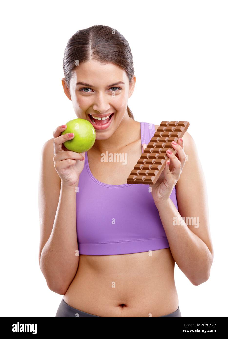 Du verdienst dir deinen Körper. Eine kräftige junge Frau, die einen Apfel in der einen Hand und Schokolade in der anderen hält. Stockfoto