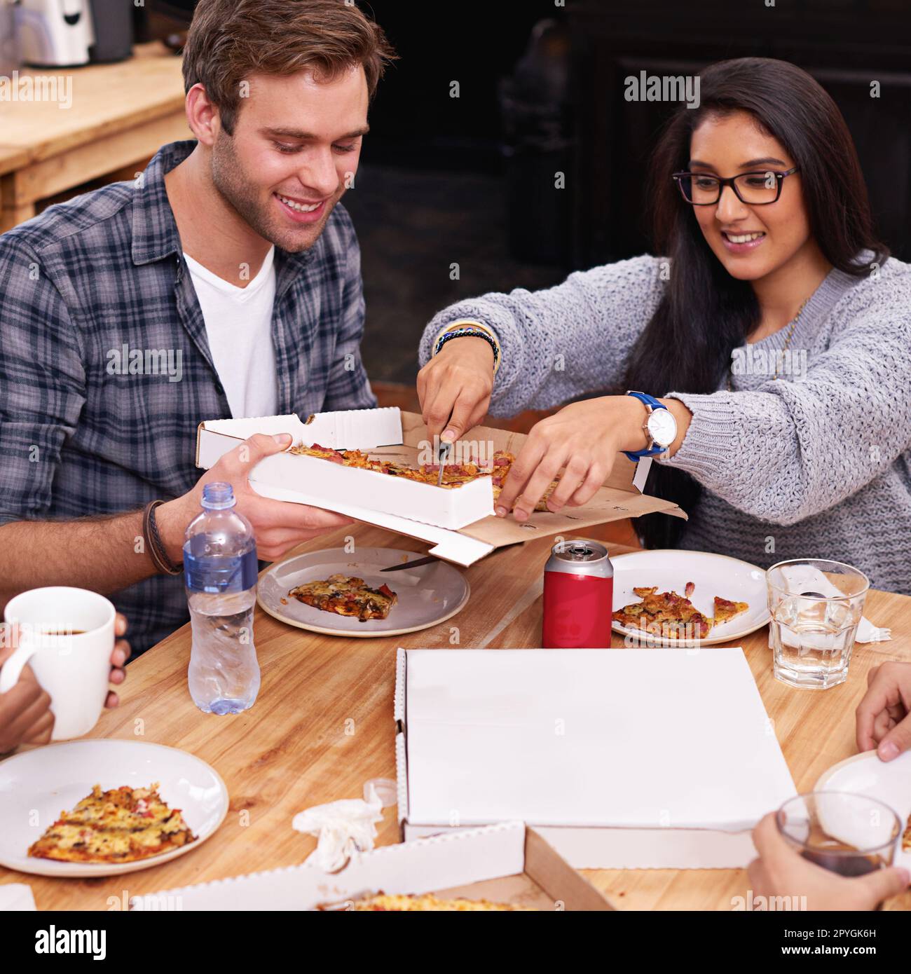 Unterhaltsame Zeiten und tolles Essen. Eine Gruppe von Freunden, die zusammen Pizza essen. Stockfoto
