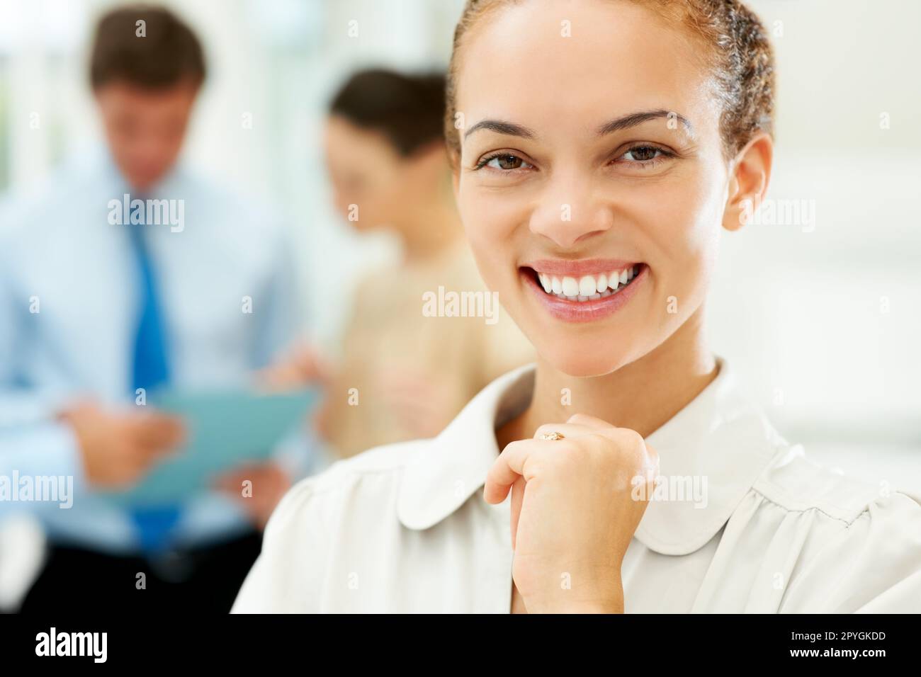 Nahaufnahme einer glücklichen und erfolgreichen Geschäftsfrau. Nahaufnahme einer glücklichen und erfolgreichen Geschäftsfrau mit Menschen im Hintergrund. Stockfoto