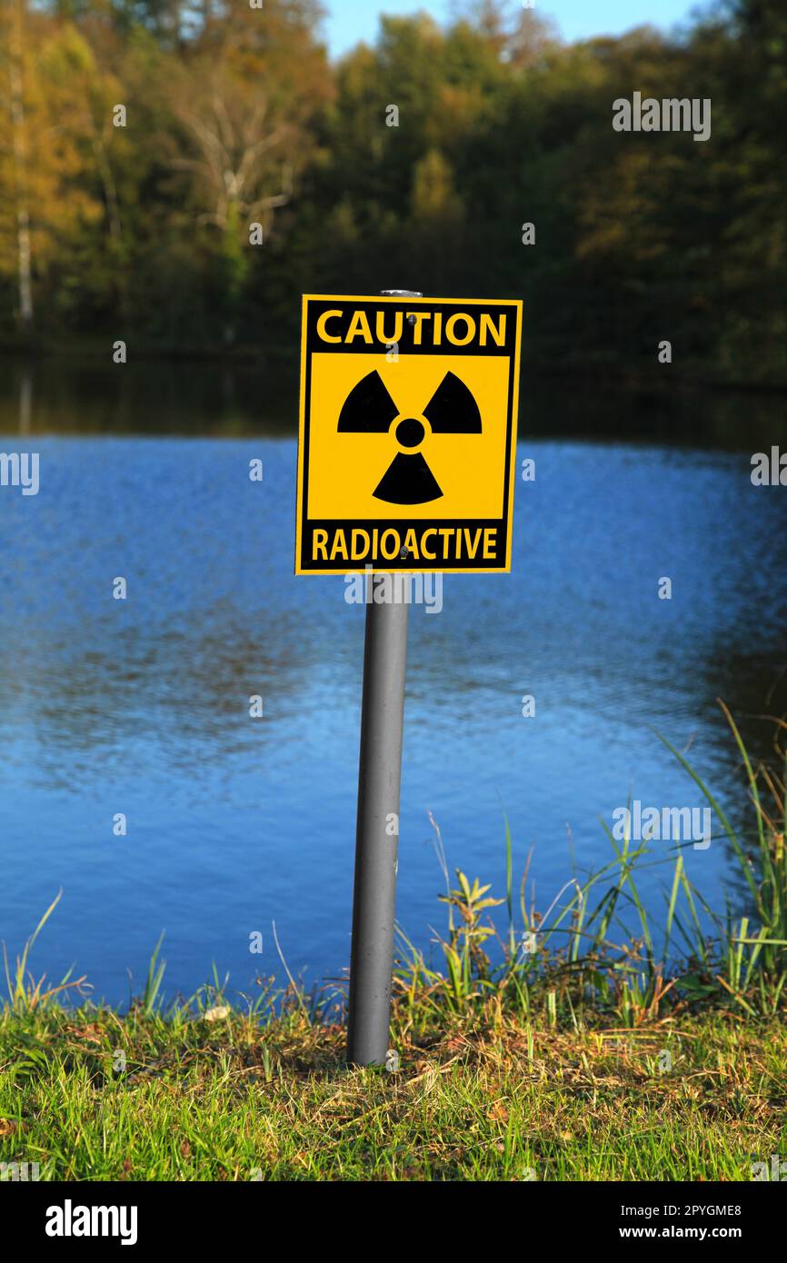 Radioaktives Warnschild an einem Seeufer. Stockfoto