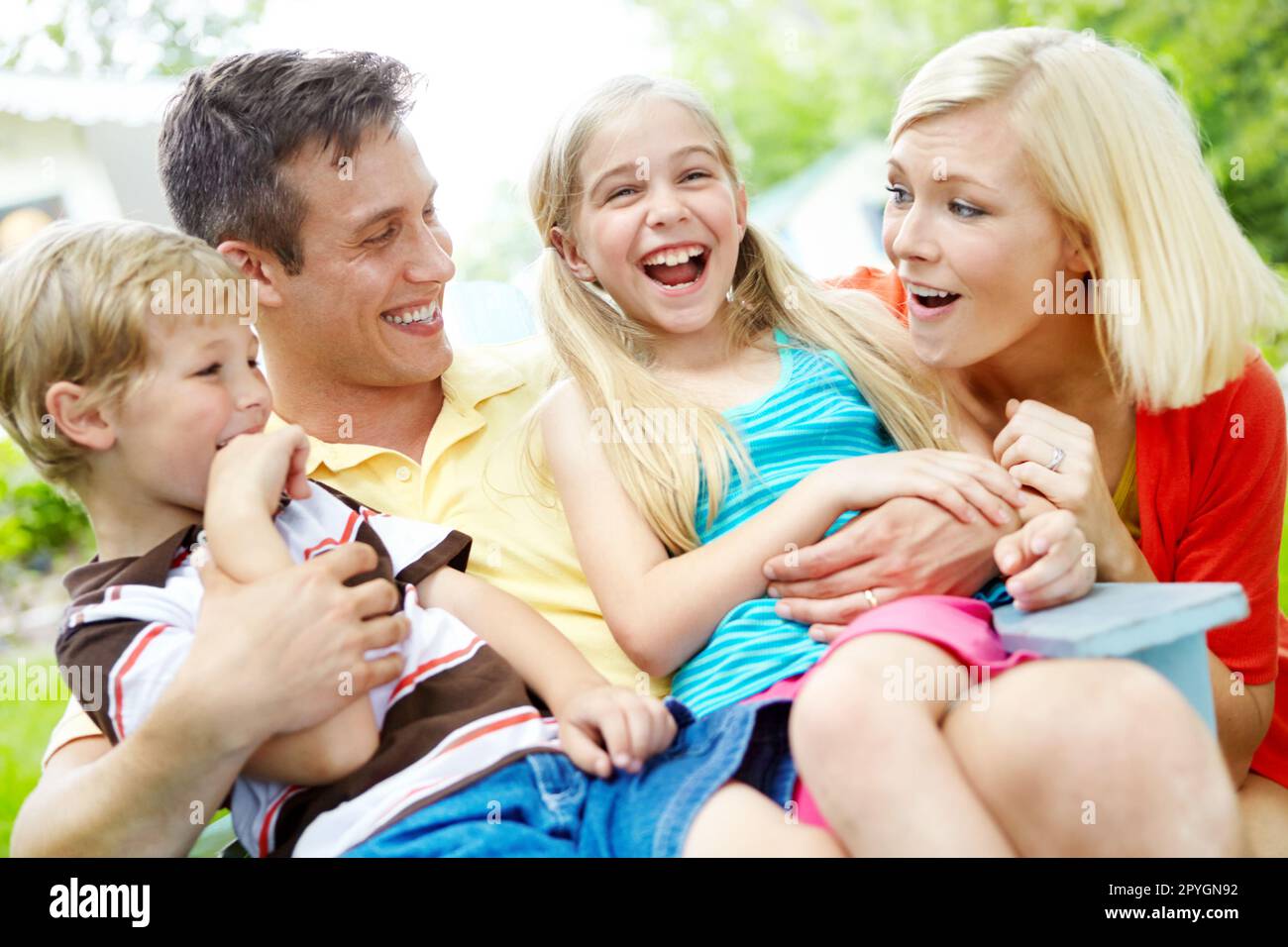 Sie sind sicher in der Liebe ihrer Eltern. Glückliche junge Familie, die Zeit zusammen im Freien verbringt. Stockfoto