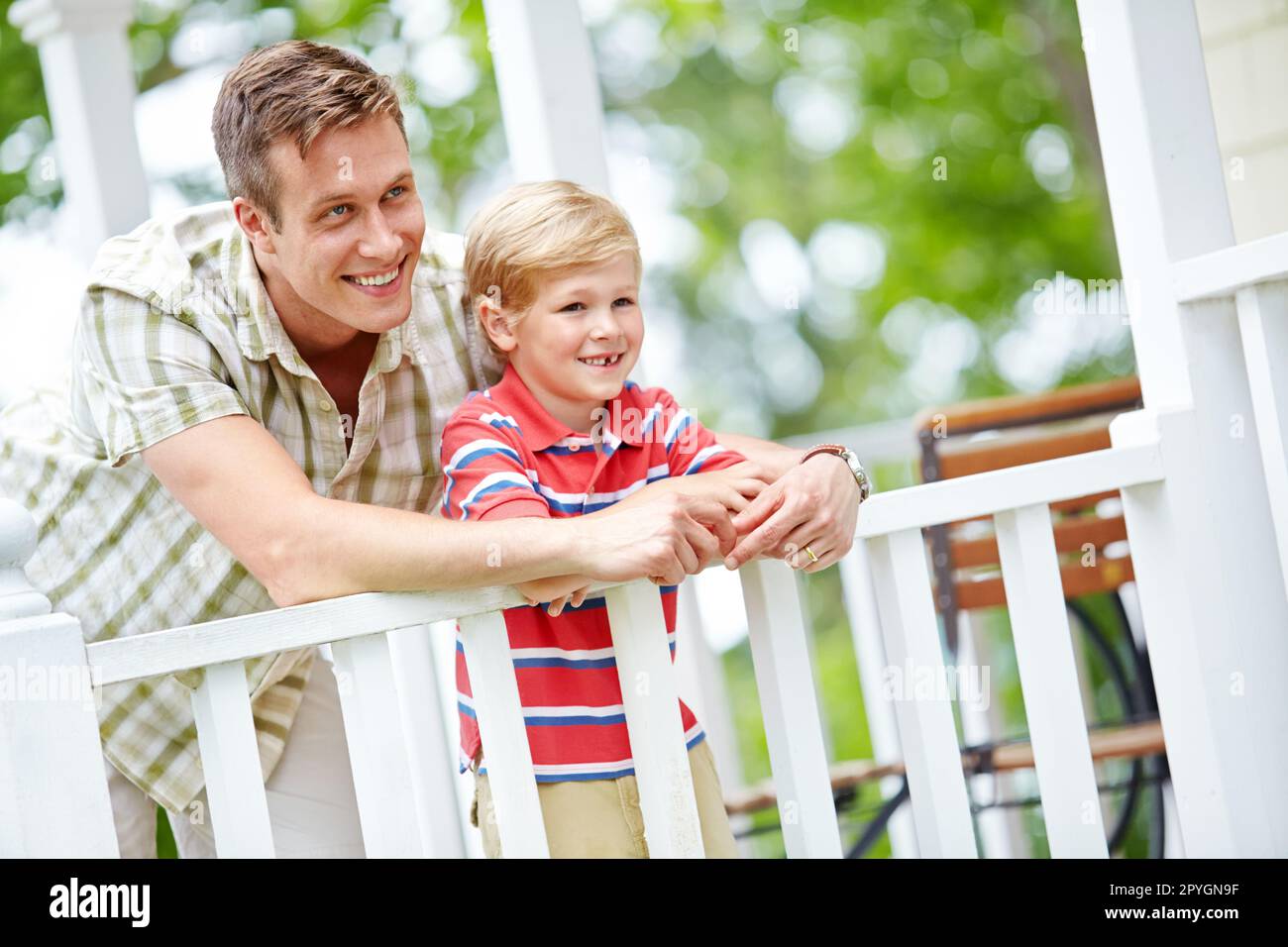 Vaterschaft ist eine kostbare Sache. Ein kleiner Junge und sein Vater teilen sich auf der Veranda etwas Qualität. Stockfoto
