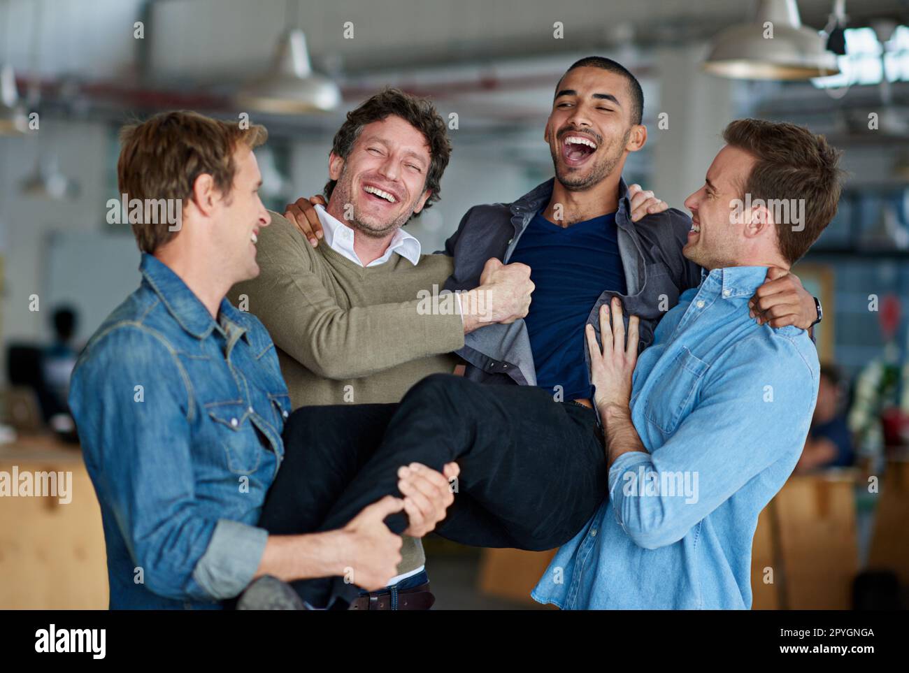 Einer von den Jungs. Eine Gruppe von männlichen Kollegen, die im Büro herumalbern und albern sind. Stockfoto