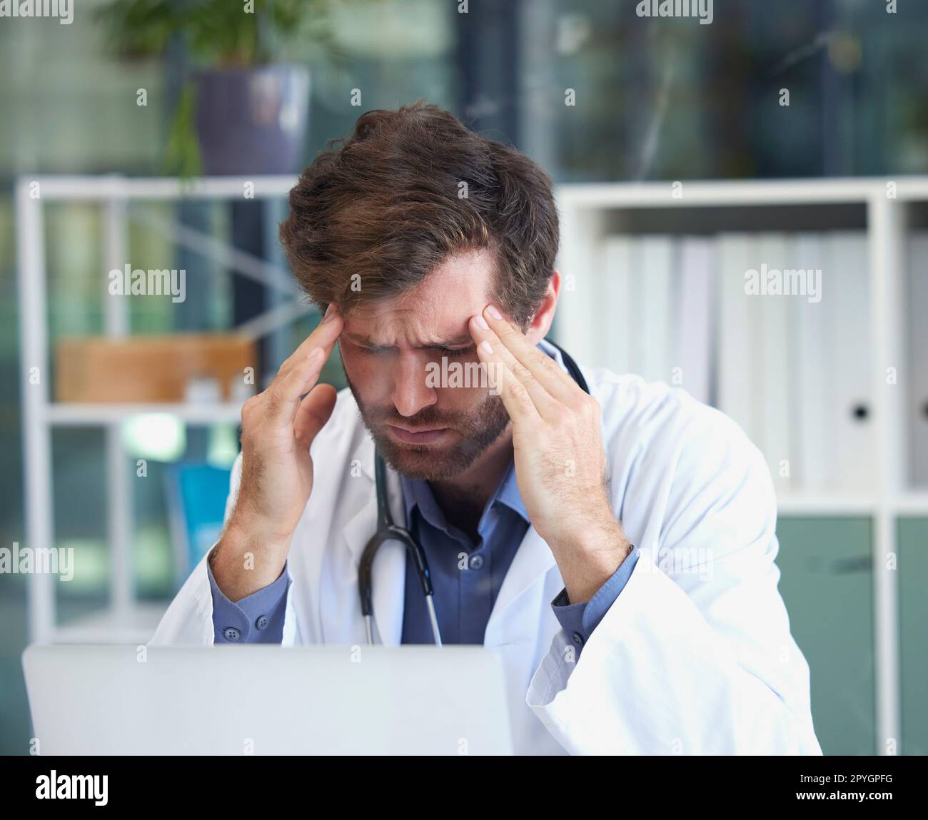 Kopfschmerzen, Burnout oder Arzt mit Stress in einem Krankenhaus denkt an Notfall, medizinische Deadline oder Druck. Migräne, Mensch oder medizinisches Fachpersonal frustriert mit psychischen Problemen oder Arbeitsangst Stockfoto