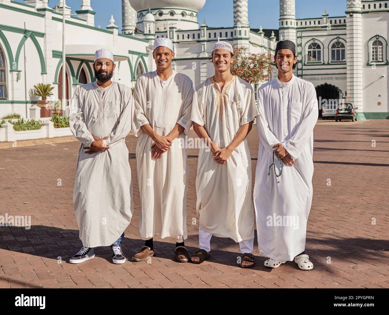 Glückliche, hajj und muslimische Männer in einer Moschee, um zu beten, ramadan Glaube und Gruppe in Mekka zusammen. Lächeln, Religion und Porträt islamischer Freunde auf einer Pilgerfahrt in die heilige Stadt für eine spirituelle Reise Stockfoto