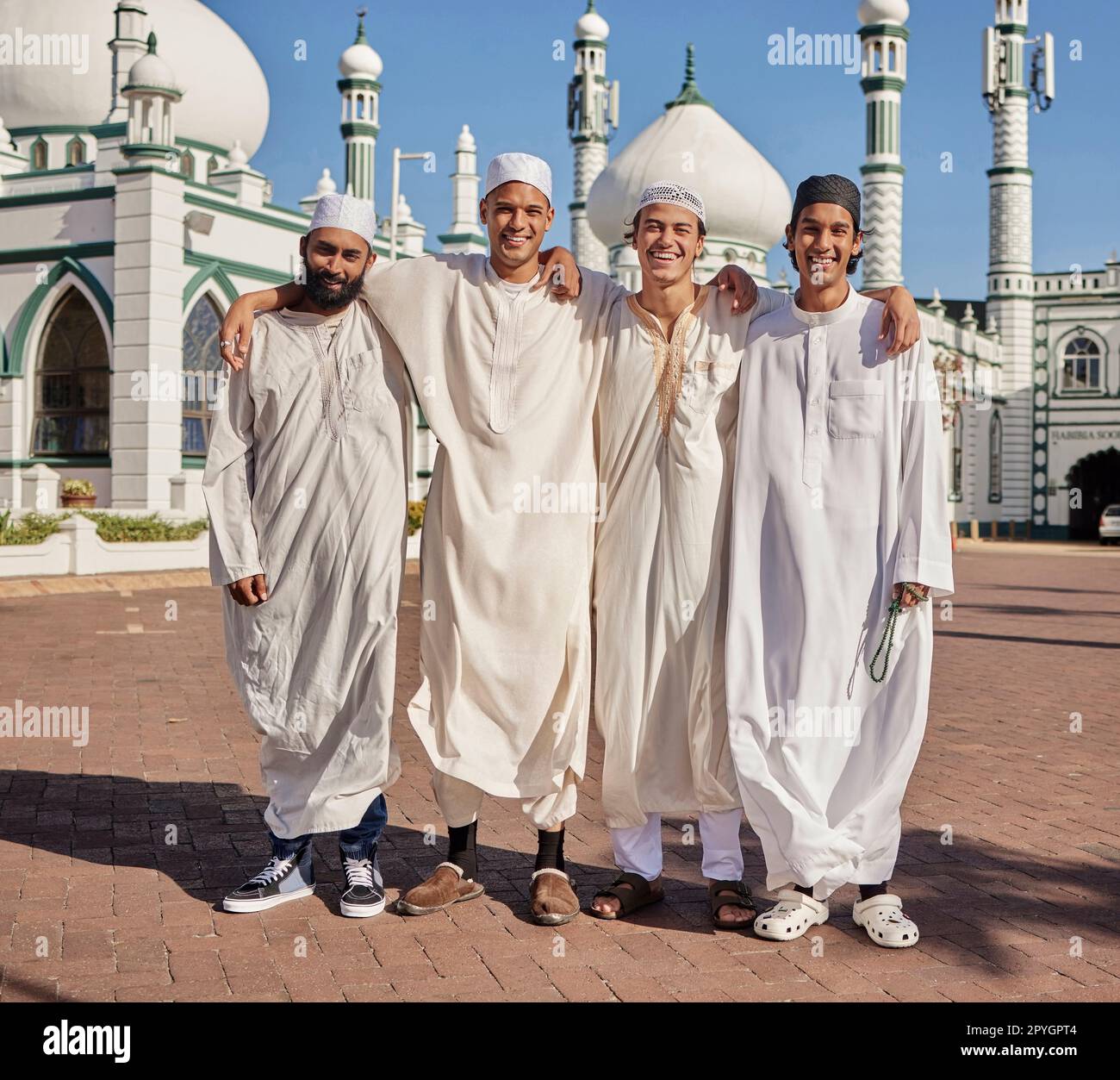 Glückliche, hajj und muslimische Männer in einer Moschee, um zu beten, ramadan Glaube und Gruppe in Mekka zusammen. Lächeln, Religion und Porträt islamischer Freunde auf einer Pilgerfahrt in die heilige Stadt für eine spirituelle Reise Stockfoto