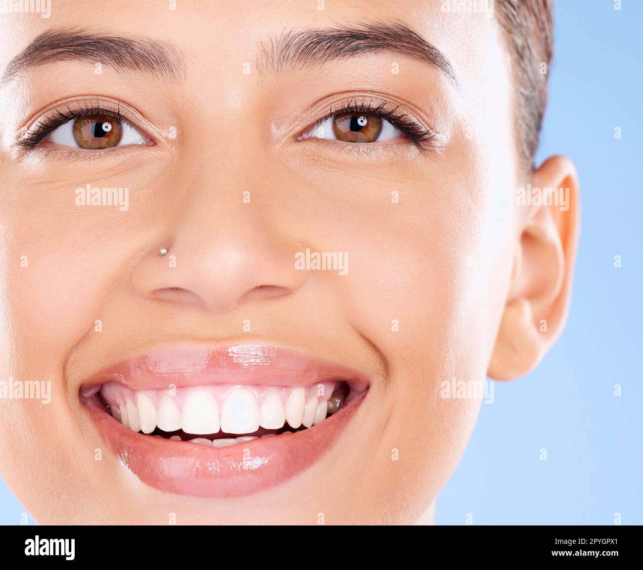 Zähne-, Zahn- und Gesichtsporträt einer Frau mit reinem Lächeln, Zahnaufhellung und Mundselbstpflege auf blauem Hintergrund. Zahnimplantat-, Gesundheits- und Schönheitsmodell mit Make-up, Kosmetik und Gesichtspflege Stockfoto