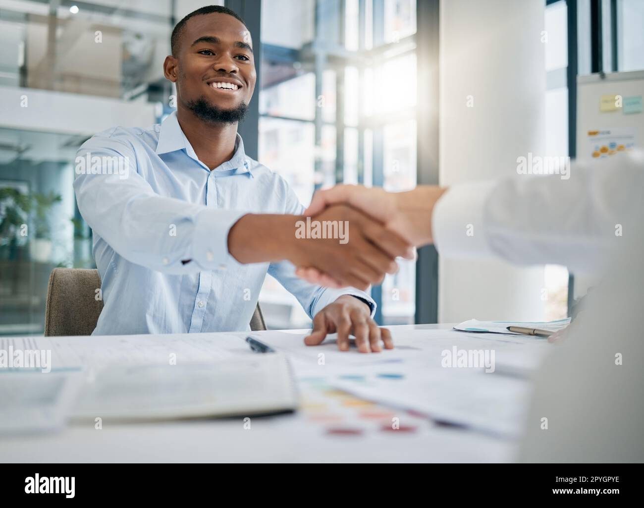 Einstellung, Designer oder schwarzer Mann, der dem Personalmanager die Hand schüttelt, um ein erfolgreiches Vorstellungsgespräch im Büro zu führen. Händeschütteln, Treffen oder Mitarbeiter mit einem fröhlichen Lächeln für eine Beförderung oder ein Geschäft Stockfoto