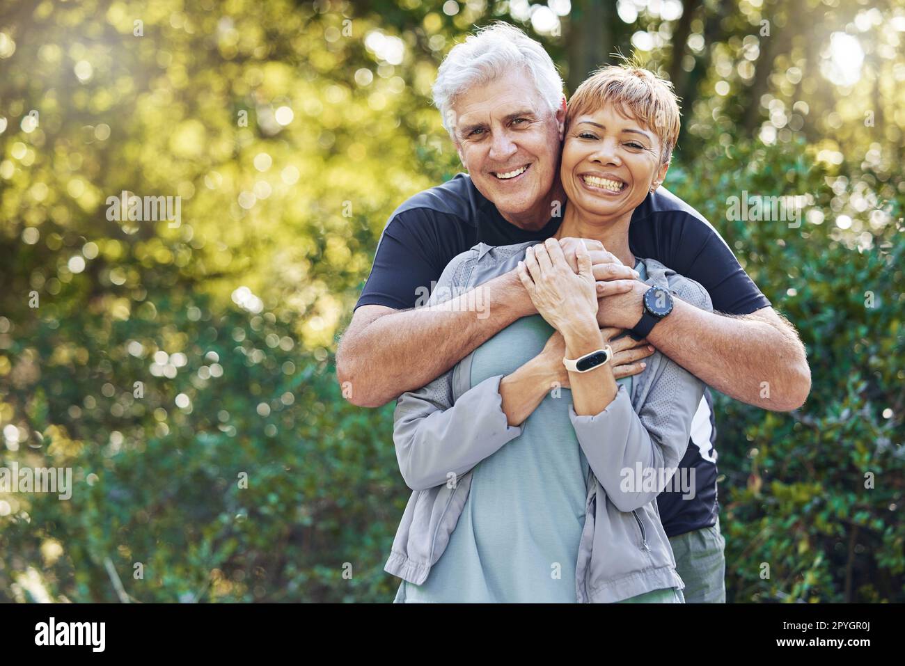 Natur, Liebe und Mann umarmen seine Frau mit Sorgfalt, Glück und Zuneigung während eines Spaziergangs im Freien. Glückliche Romantik und Porträt eines Seniorenpaares im Ruhestand, das sich im Wald, Wald oder Park umarmt. Stockfoto