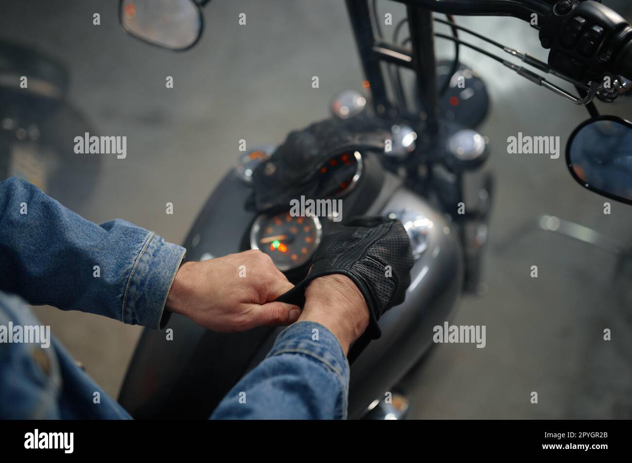 Nahaufnahme der Biker-Hand mit Lederhandschuhen über dem Motorradtank Stockfoto