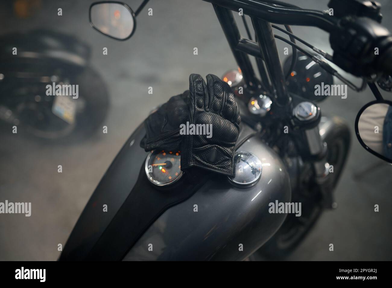 Nahaufnahme von Bikerlederhandschuhen auf Motorradgastank Stockfoto