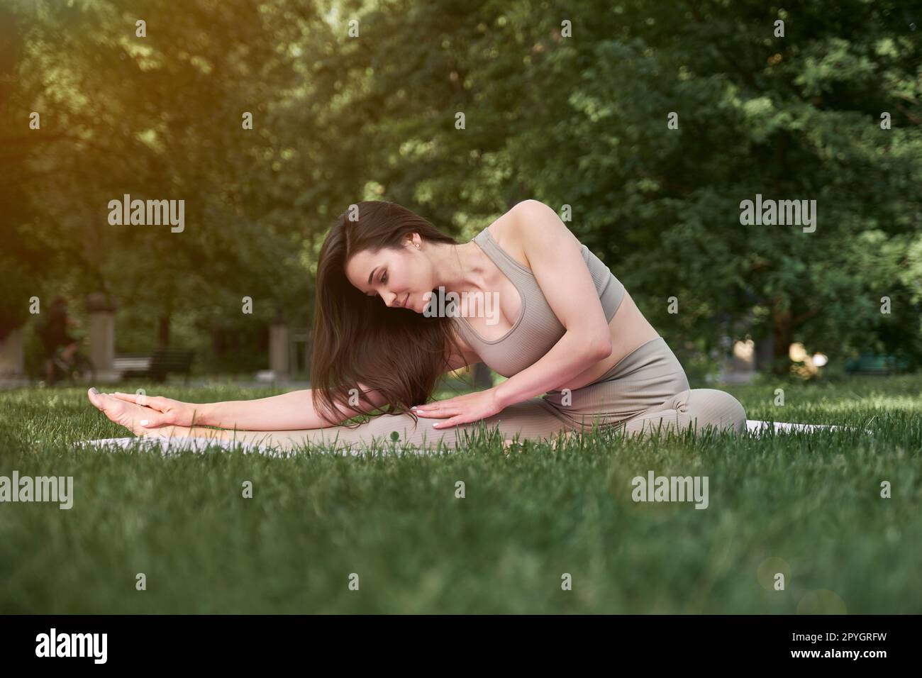 Eine junge Frau mit schlanker Figur und langen Haaren geht an einem warmen Sommertag in den Park. Stockfoto