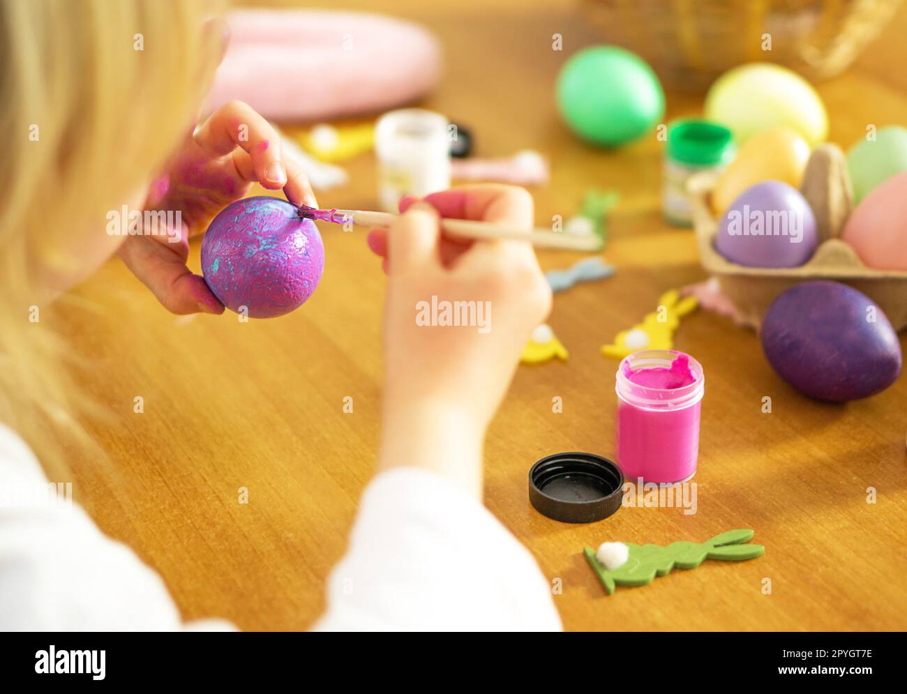 Letle Kinderhände malen Ostereier auf Holztisch. Frohe Ostern. Vorbereitung auf die Osterfeier. Stockfoto