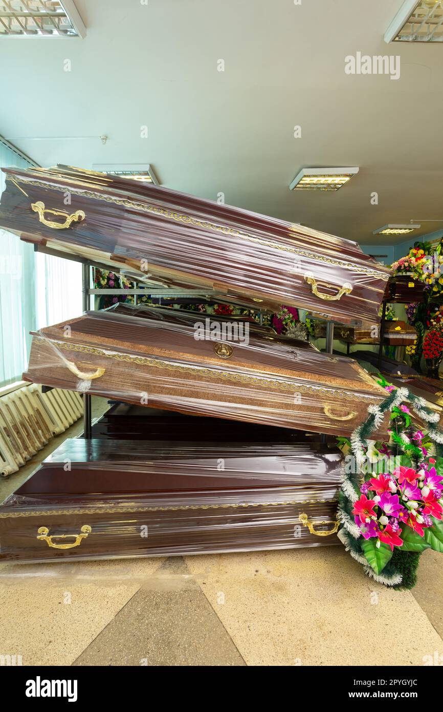 Innenraum des Raumes mit Bestattungszubehör. Geschäft mit Särgen, Beerdigungskränzen und Blumen. Stockfoto
