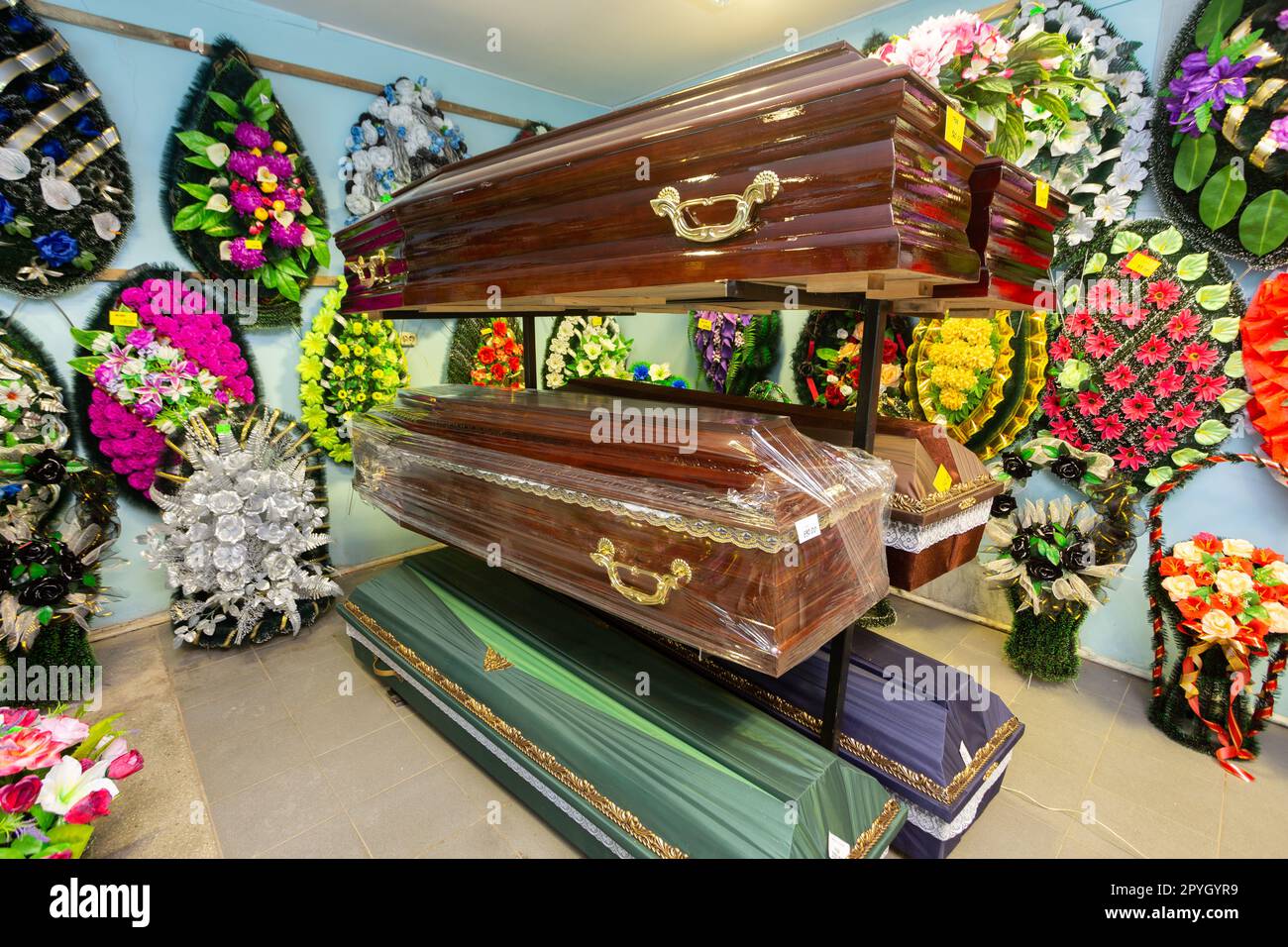 Innenraum des Raumes mit Bestattungszubehör. Geschäft mit Särgen, Beerdigungskränzen und Blumen. Stockfoto
